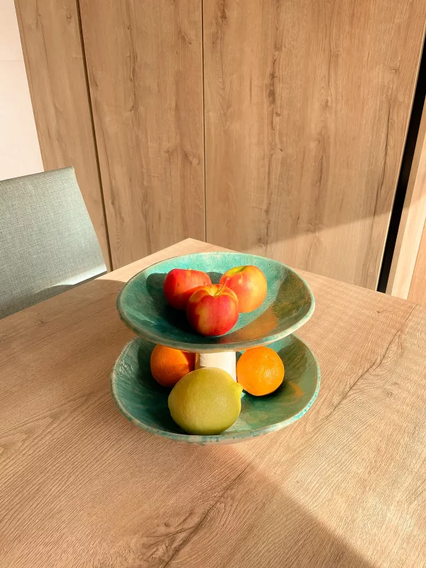 Frutero encima de mesa con manzanas, naranjas y limones