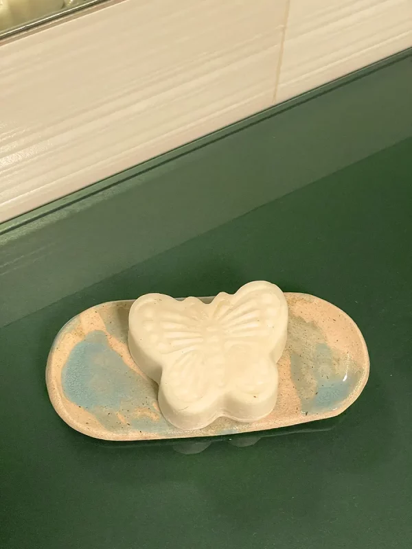 Jabonera hecha a mano de cerámica con una pastilla de jabón con forma de mariposa