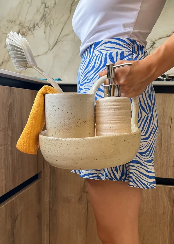 Chica sostiene el set de limpieza para cocina