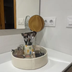 Set de maquillaje de cerámica hecho a mano encima de la pica del baño