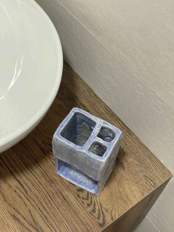 Detalle de soporte de cepillo de dientes en baño hecho de cerámica