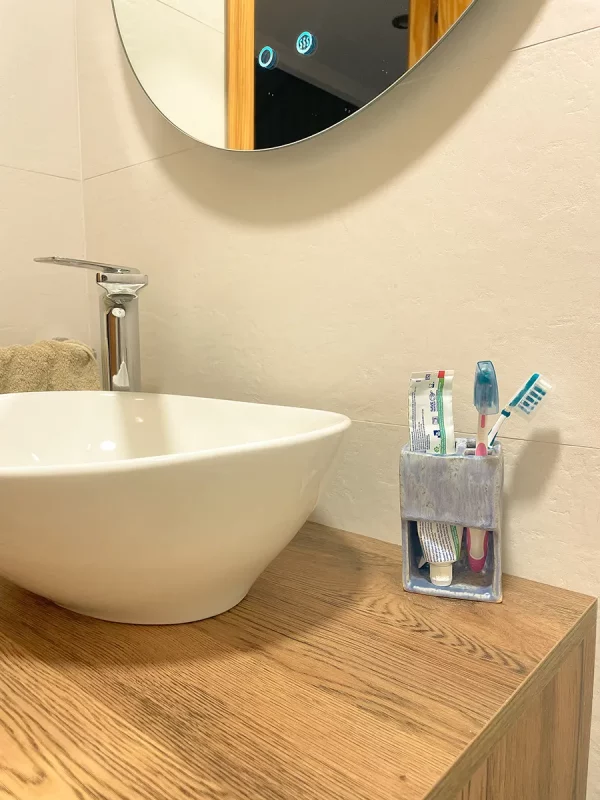 Mueble de baño con un soporte de cepillo de dientes hecho de cerámica