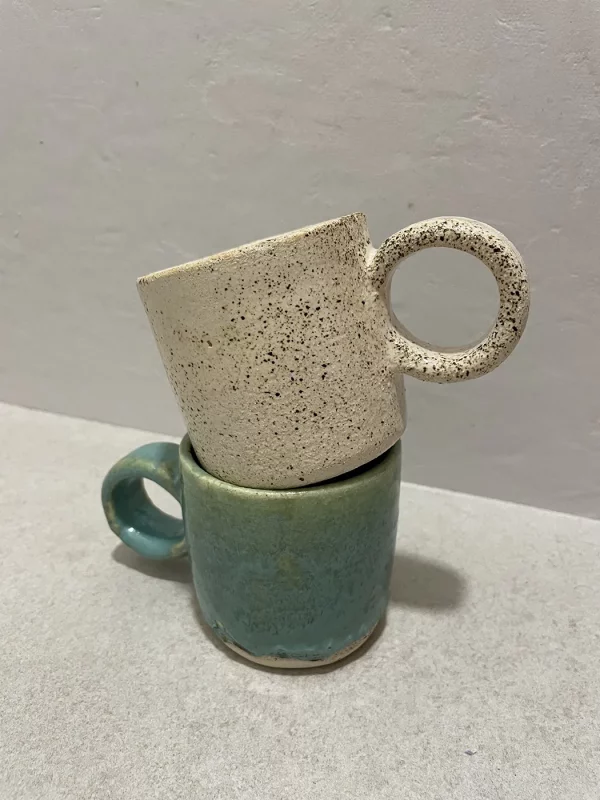 Dos tazas hechas completamente de manera artesanal con acabado redondo y colorido superpuestas entre si al detalle