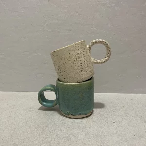 Dos tazas hechas completamente de manera artesanal con acabado redondo y colorido superpuestas entre si